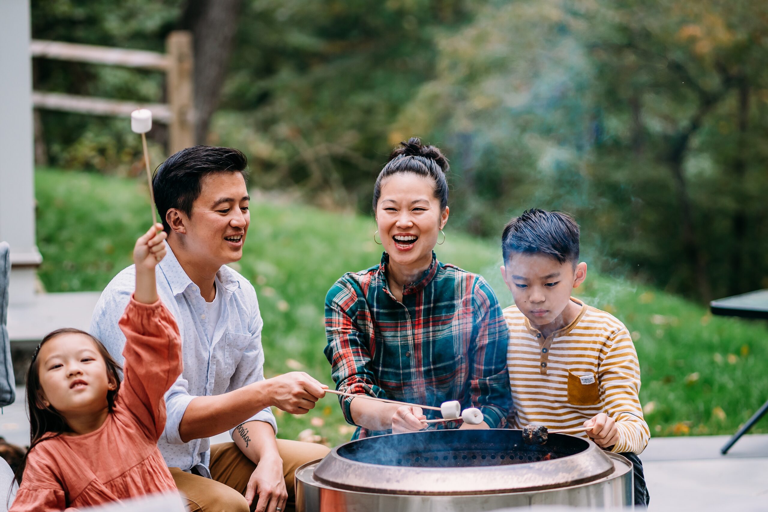 mother father and two children roast marshmallows around a solo stove